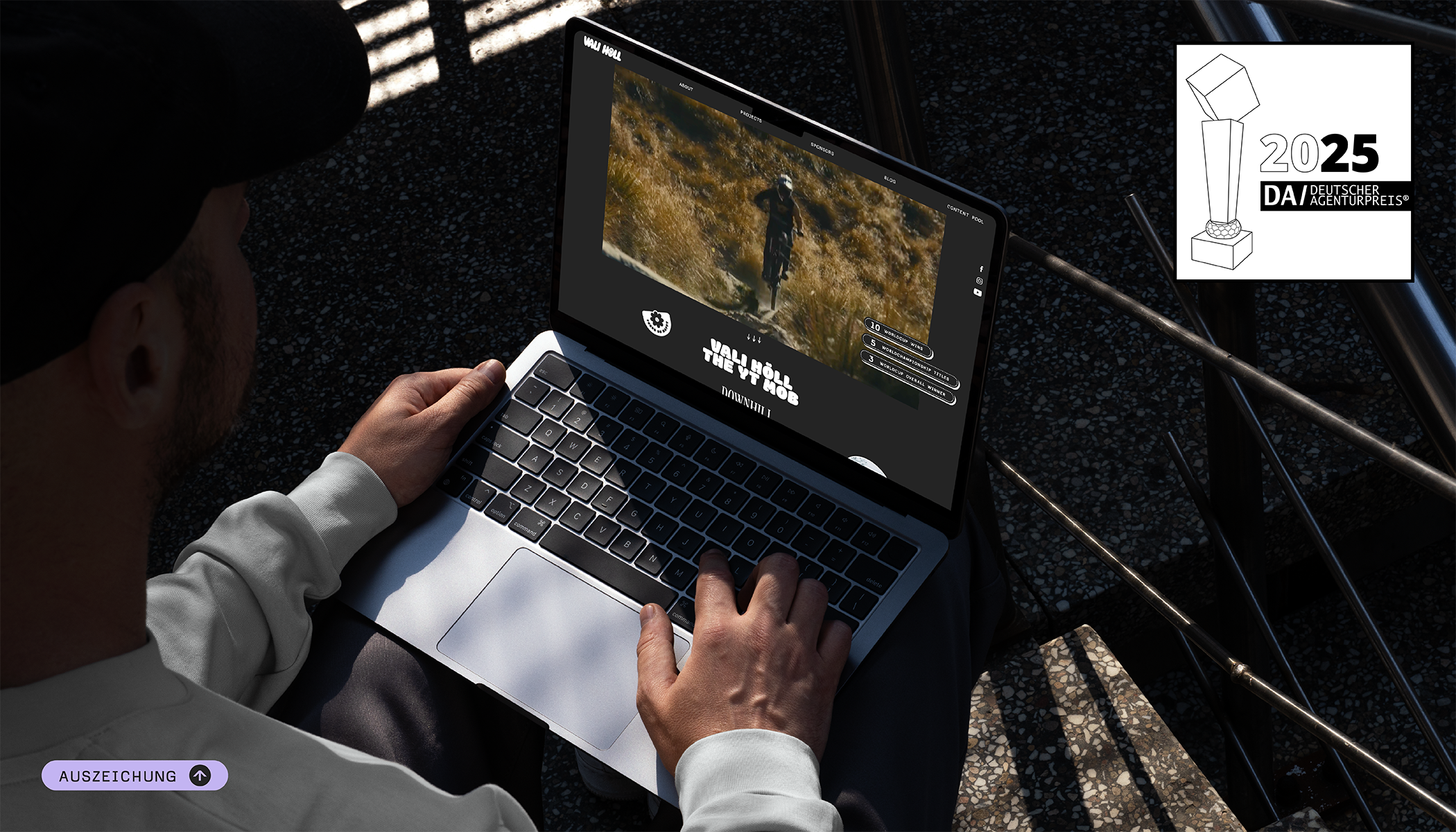 Person tippt auf Laptop, Mountainbike-Video läuft.