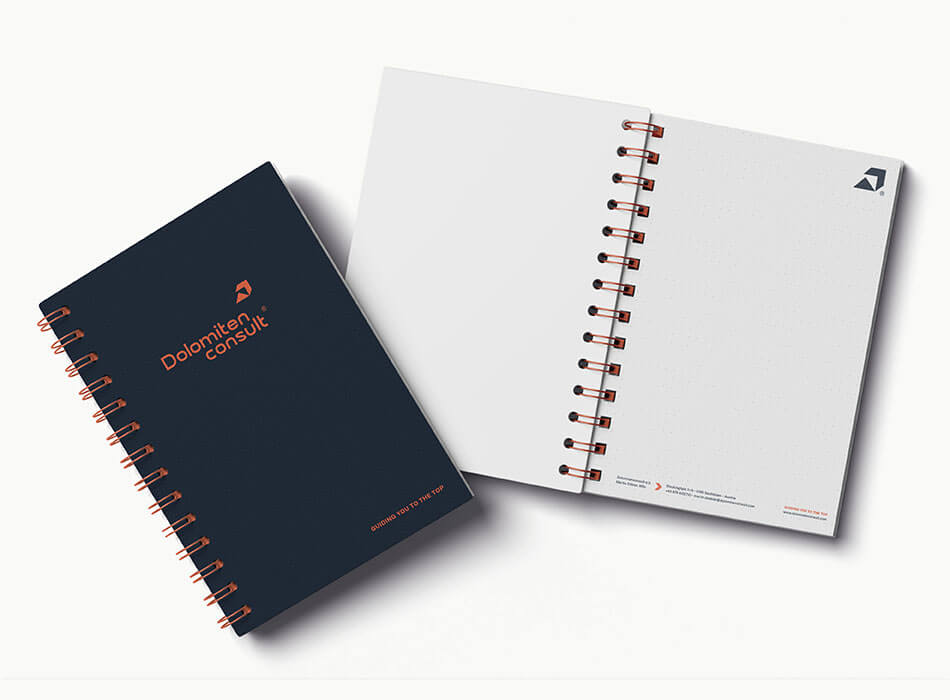 Zwei spiralgebundene Notizbücher, eines offen, eines zu.