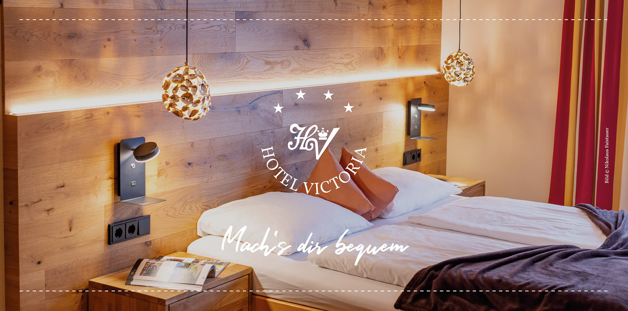 Hotelbett mit Holz-Kopfteil, Leselampen, Hängelampen.