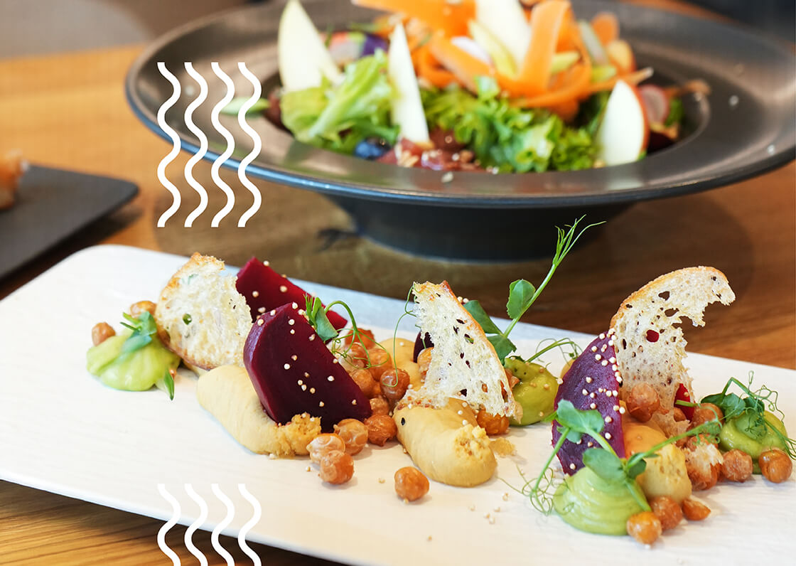 Teller mit Rote Bete, Brot, Pürees, Kichererbsen.